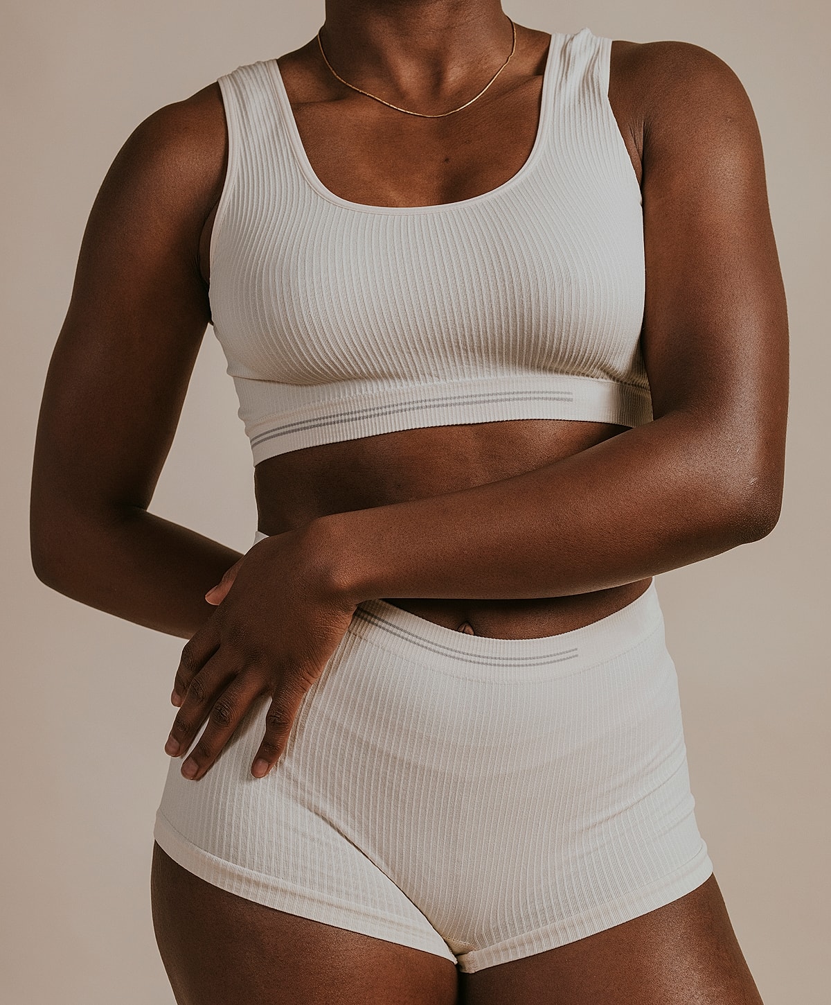 Model wearing ribbed beige activewear set.