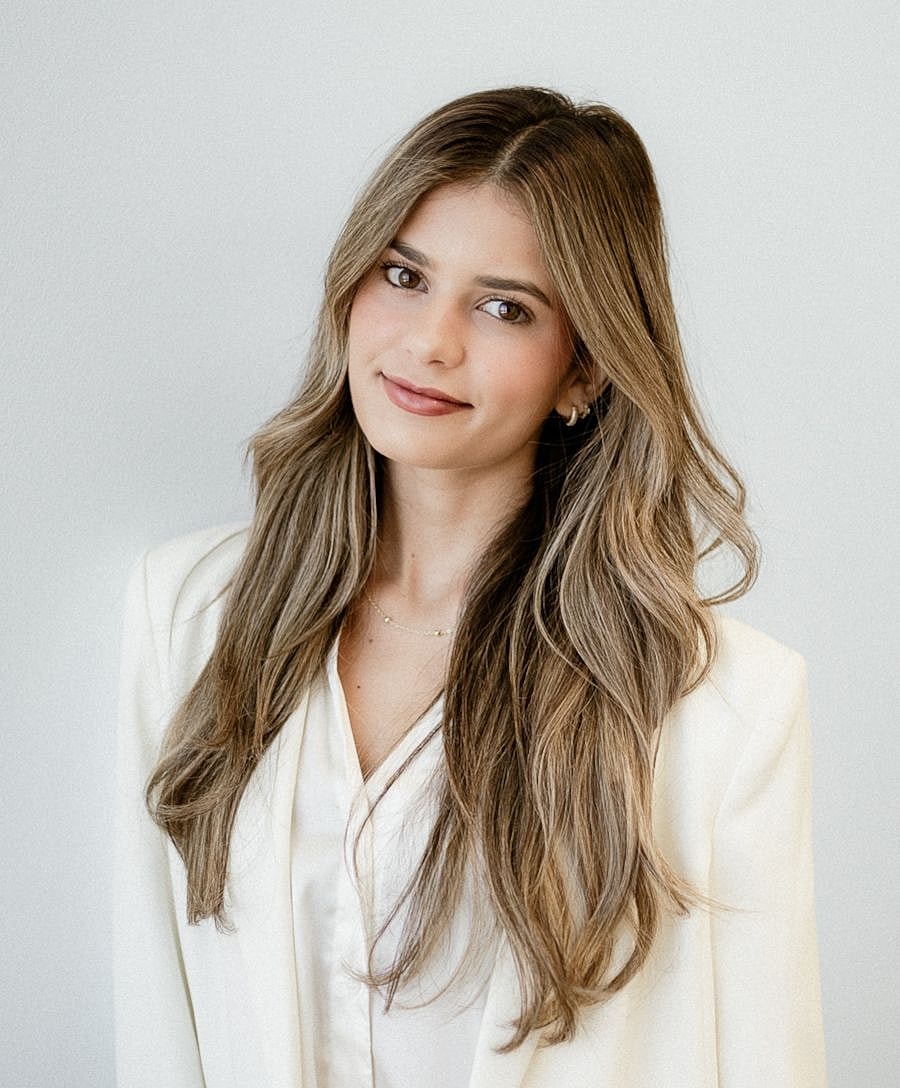Woman with long hair wearing a white blazer.