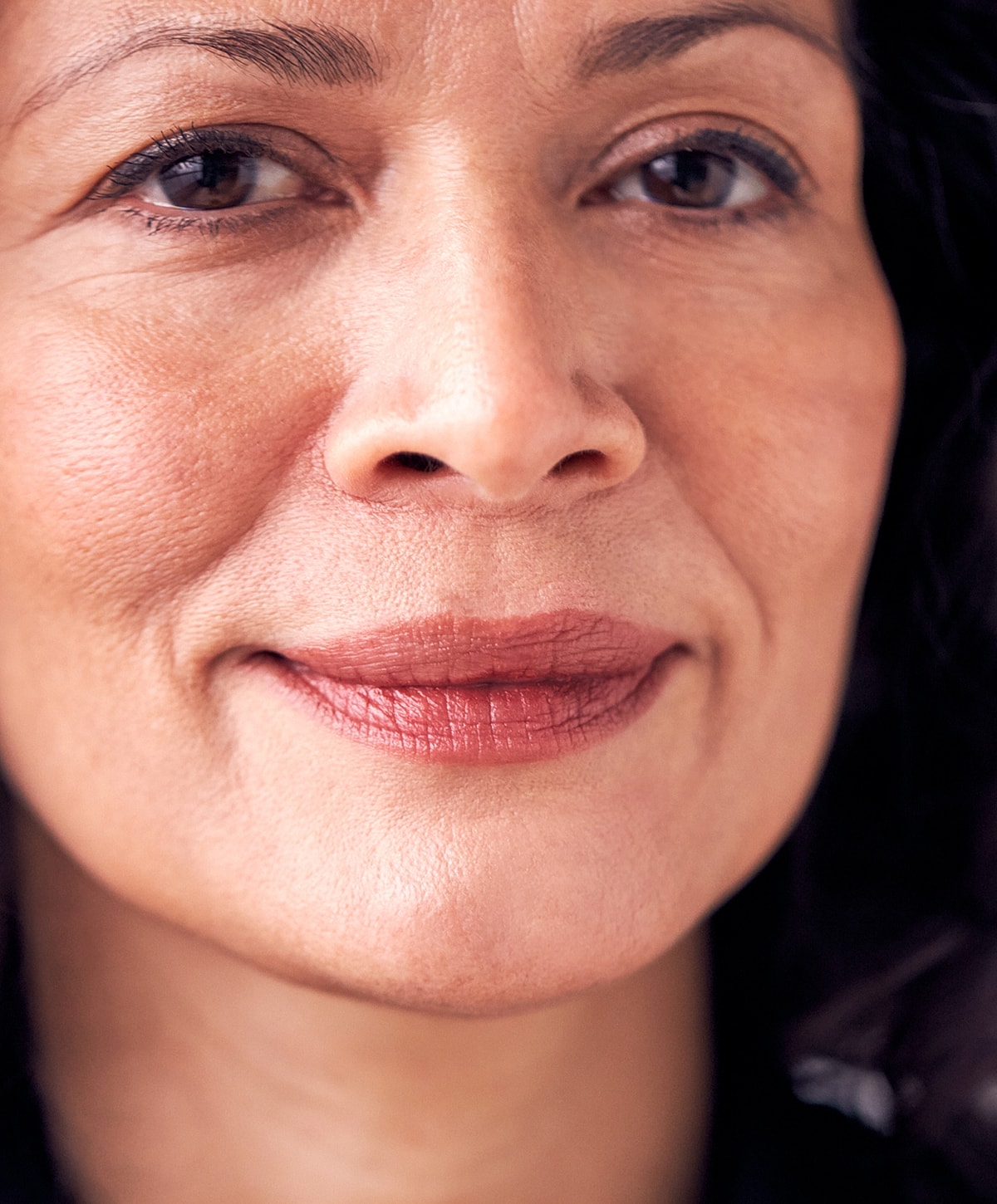 Close-up of a woman's face smiling gently.