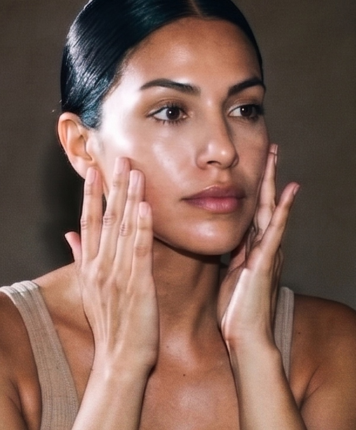 Woman applying skincare to her face.