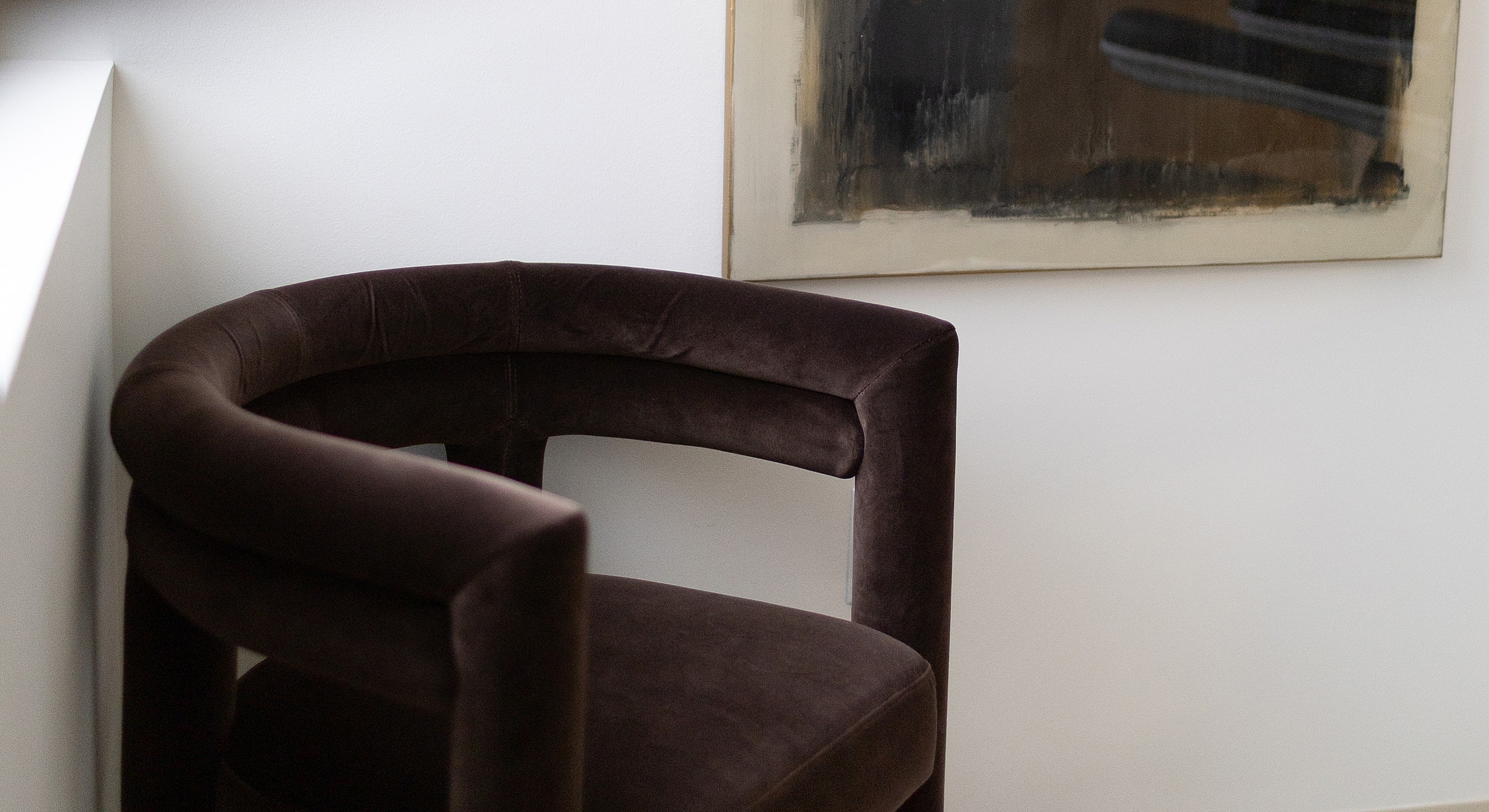 Stylish brown chair against a minimalist wall.