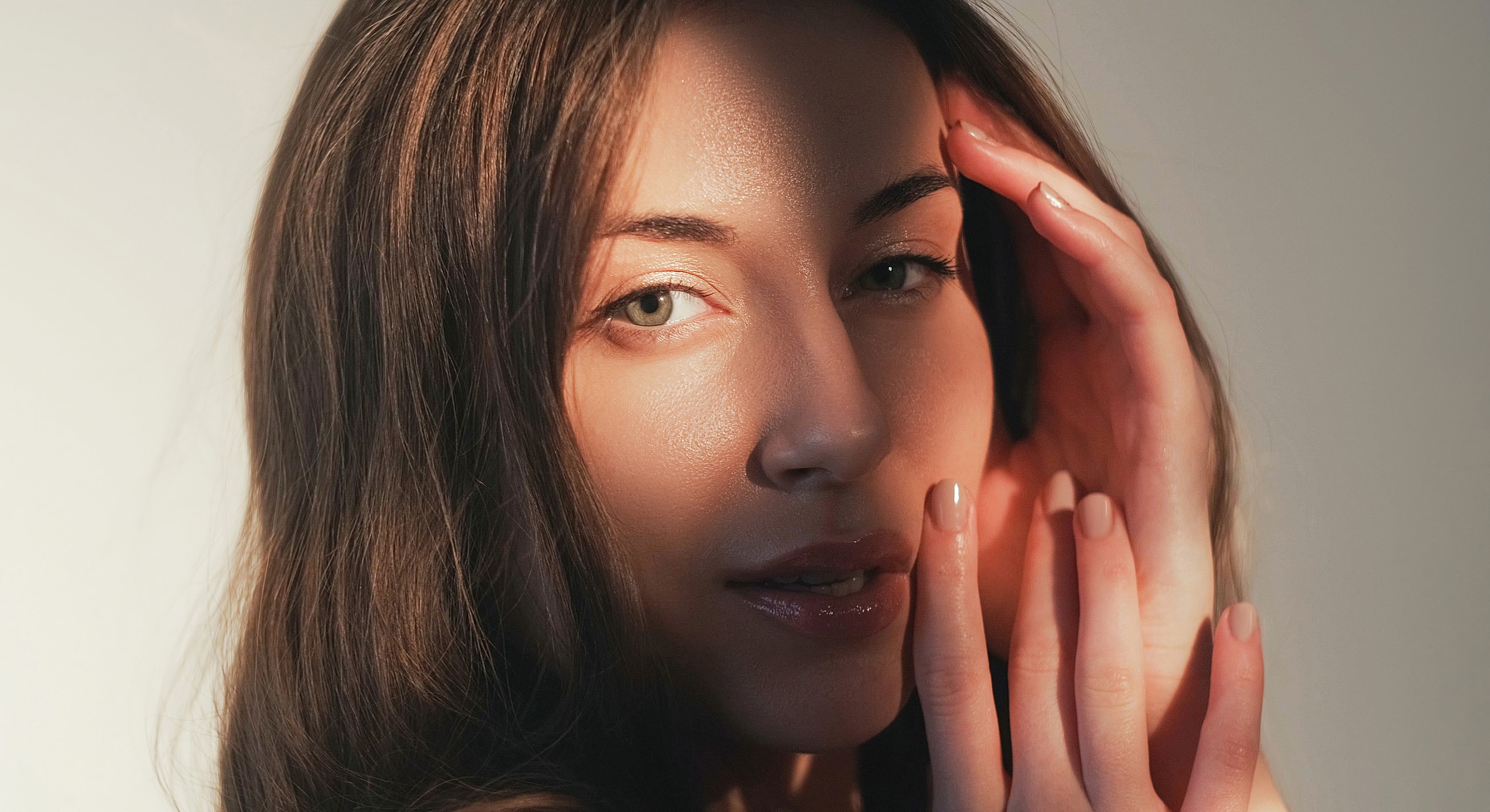 Close-up of a woman's face with hands.