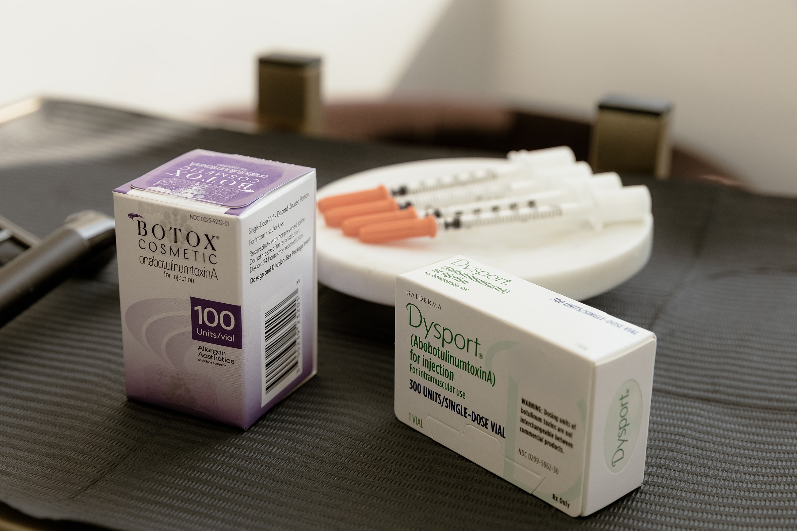 Botox and Dysport boxes with syringes on table