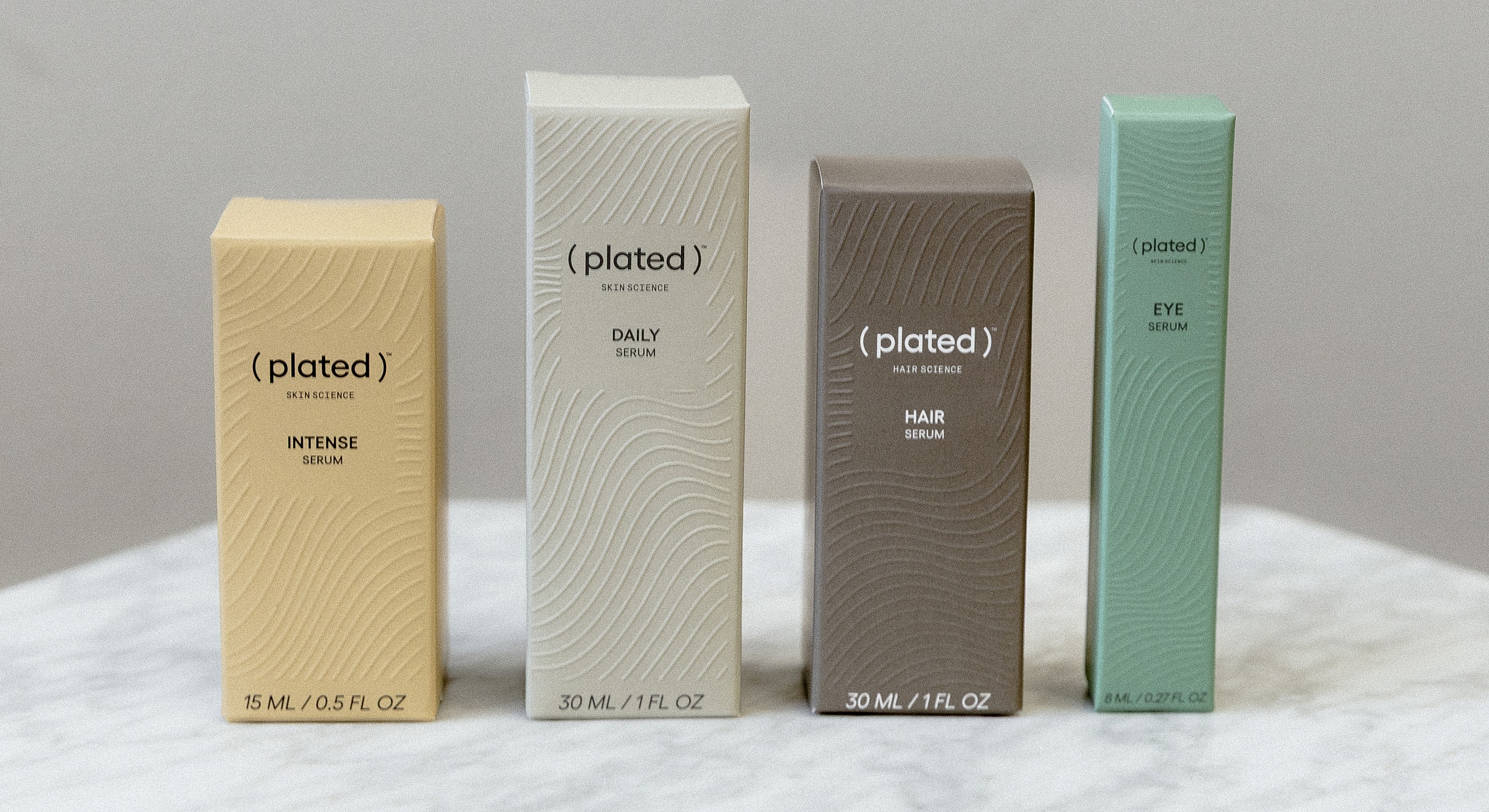 Plated skin and hair serums arranged on marble.