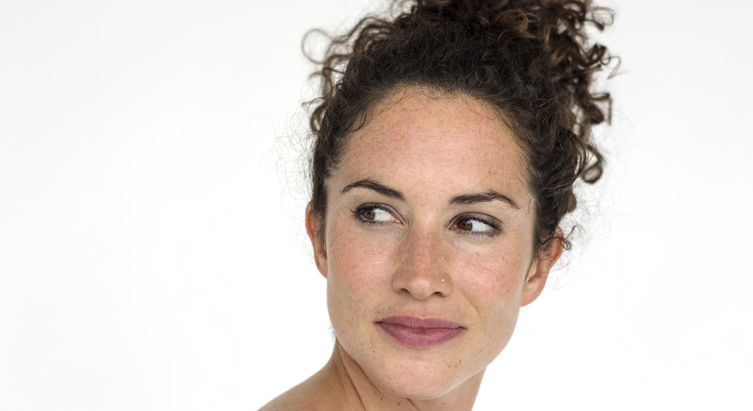 Woman with curly hair looking to the side.
